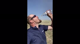 Funny fail: Man tries to swig from bottle of water in Alberta, Canada in blowy weather