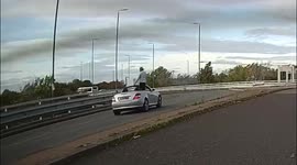 Man in a convertible Mercedes dances on the seat while his car drives itself