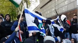 Pro-Palestinian protesters cheer as they burn multiple Israeli flags outside embassy in London