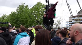 Man City fans climb traffic lights as team bus arrives ahead of final home game of season