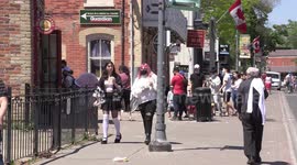 People out enjoying the nice beautiful summer sunny weather socially distanced and wearing masks near Toronto on the long Victoria day holiday weekend on Mainstreet unionville Markham
