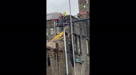 Demolition crew assisting firefighters at scene of large fire in Bradford