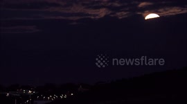 Full Flower Supermoon rising through cloud cover in Kent, UK