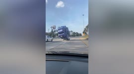 Pickup truck overloaded with fifteen water tanks wobbles along highway