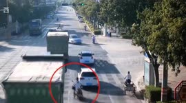 Scooter driver avoids serious injury after being knocked over by truck in southwestern China