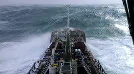 Sailor watches on anxiously as ship battles monster waves in the Atlantic Ocean