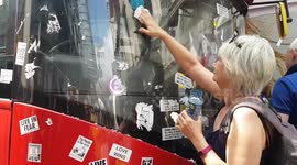 Kind people help remove anti-vaccine stickers from London bus that COVID-19 sceptics pasted