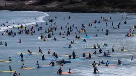 Dozens of surfers flock to Polzeath beach in Cornwall for Bank Holiday weekend