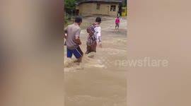 Residents brave flash floods to reach higher ground during tropical storm Choi-wan in the Philippines