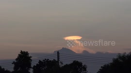Strange bright cloud in a night sky over a paddy field in Thailand, looks like a UFO.
