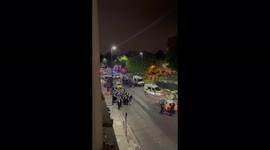 Police in riot gear marching through Brixton in response to a reported incident