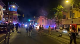 Police guard an intersection on Hennepin Ave in Minneapolis, Minnesota as dumpsters burn beside them