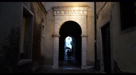 Venice during Covid19 lockdown, Italy, Europe, couple walking through La Biennale arch, at night with umbrella