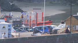 RNLI lifeboat reacts to a real emergency. At Newquay Cornwall The 'Gladys Mildred' B Class Atlantic 85 RIB lifeboat launches with full volunteer crew after reports of two individuals on a rock cut off by the tide.