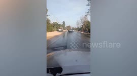 Farm truck overloaded with hay leans dangerously to the side