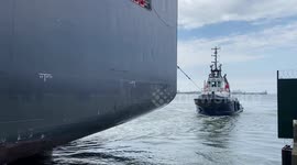 Tug tows large ship in Zeebrugge, Europes largest container port in Belgium.