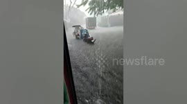 Taxi cab is stuck in knee-deep flood during heavy rain fall in the Philippines