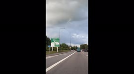 Funnel cloud reaches out of the storm cloud in the UK.