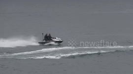 G7 police officers struggle to control a jet ski as they race past quiet Cornish town of St Ives