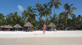 Tourist walking onto a beach in the maldives 2