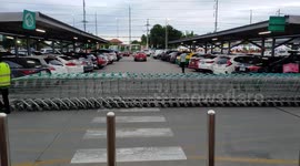Supermarket trolley convoy holds up traffic at a supermarket in Thailand.
