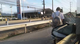 Two pet cats ride join owner on motorcycle by sitting inside clear rucksack