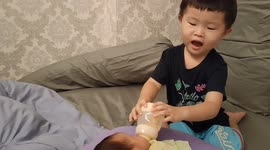 Adorable moment of brother milk feeding baby sister