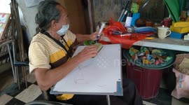 Indonesian artist in a wheelchair creates a painting