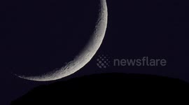 Stunning high-definition footage of crescent moon setting behind Swiss Alps