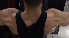 Strong muscular guy workout pull ups with 100 kg in the gym.