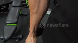 Strong man workout his biceps and arms in the gym.