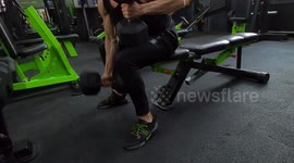 fitness guy workut his chest muscle with a big dummbells in the gym.