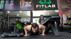 Fitness guru doing advanced push ups in the gym.