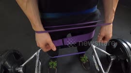 Strong man doing advanced squats with elastic bands.