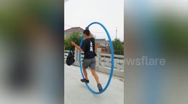 Chinese man shows off incredible acrobatic skill by walking in giant steel hoop