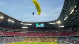 Fans react as Greenpeace parachutist skims their heads during Euro 2020 game