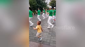 Toddler nails dance routines performed by group of women at Chinese park