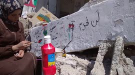 Palestinian artist paints on rubble of home damaged by Israeli airstrikes