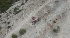 Enduro motorcycles climbing a mountain of fine white sand. Enduro sport with dirt bikes