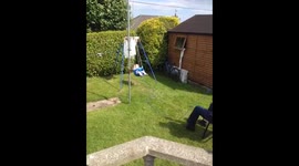 Grandad pulls Granddaughter in swing by a rope as he sits in chair!