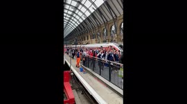 Scotland fans arriving in London for Euro 2020 clash with England, with a non plussed rail worker looking on