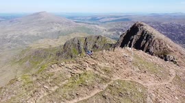 Amazing aerial footage of Snowdonia in Wales. Bank Holiday Summer 2021. Drone footage along the cool Cliff Walk along Y Lliwed. Peaceful natural trail and scrambling in the UK. Hiking. Drone. Snowdon. Blue sky. Mountain.