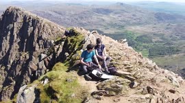 Amazing aerial footage of Snowdonia in Wales. Bank Holiday Summer 2021. Drone footage along the cool Cliff Walk along Y Lliwed. Peaceful natural trail and scrambling in the UK. Hiking. Drone. Snowdon. Blue sky. Mountain.