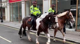 Friendly London Met Police on horseback wave as they clip-clop through the backstreets of Covent Garden