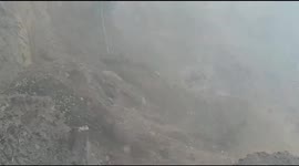 Workers move back moments before landslide crashes onto road in India