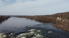 Man fly fishing in the middle of Delaware River with swooping aerial drone shots
