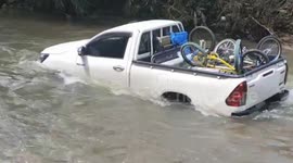 Car saved from flooded stream after heavy rain in central Thailand