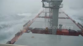 Bulk carrier powers through high waves whipped by typhoon off China's coast