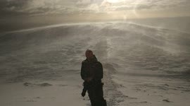 Man standing in the snow on top of a mountain as the sun comes up. Scotland 2018