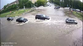 Motorists resort to pushing their vehicles through street submerged by floodwater in Russia